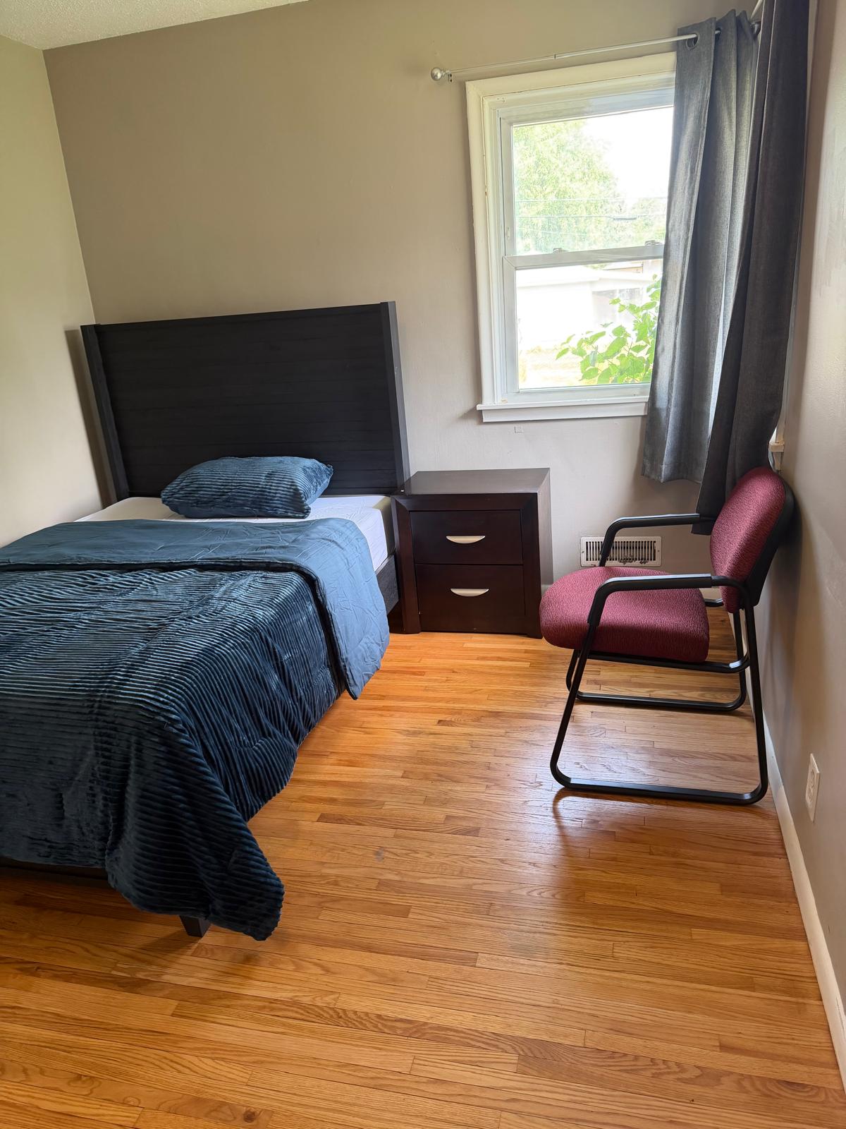 Private bedroom with a bright window and sitting chair