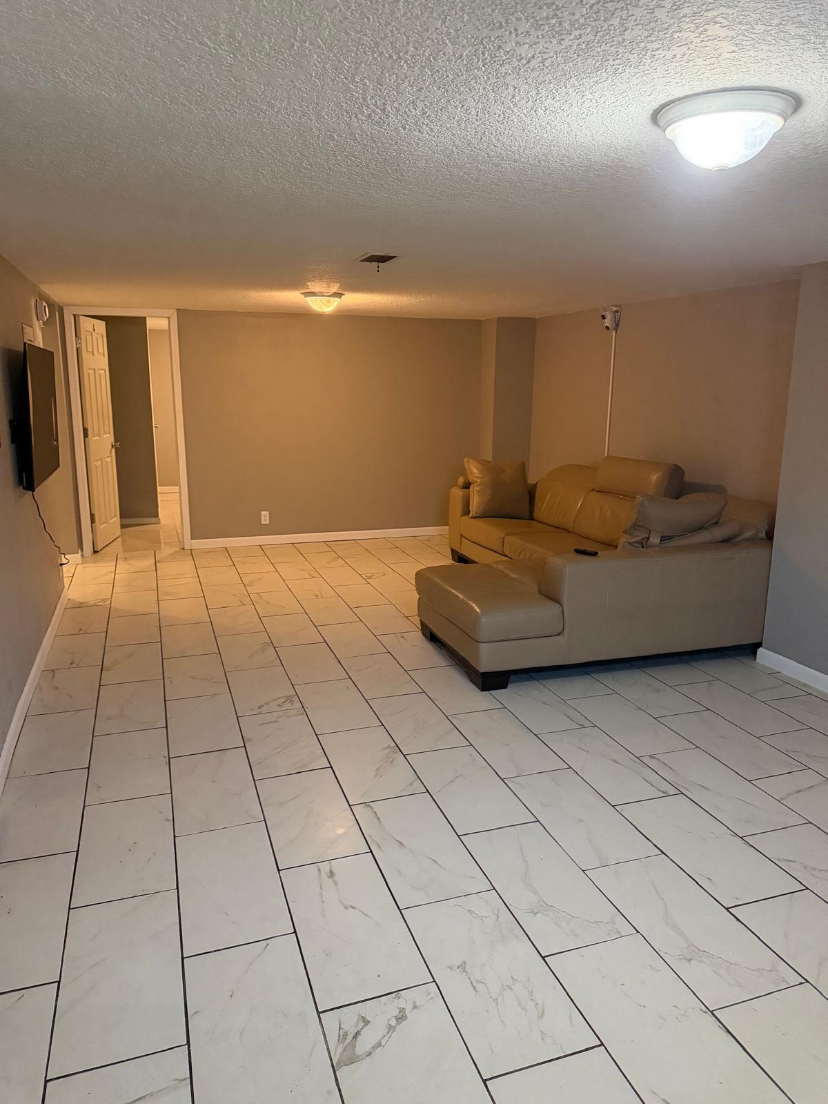 Spacious living room with comfortable seating and tiled floors
