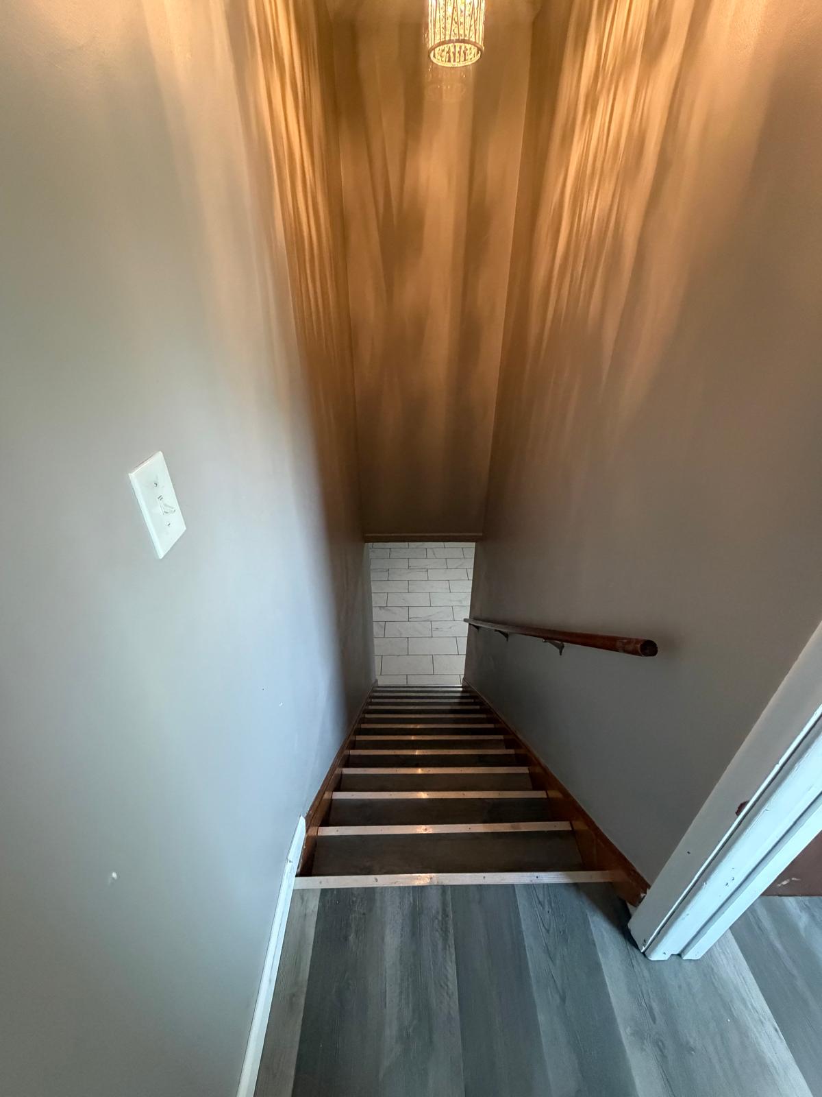 Interior stairway with handrail and wood steps